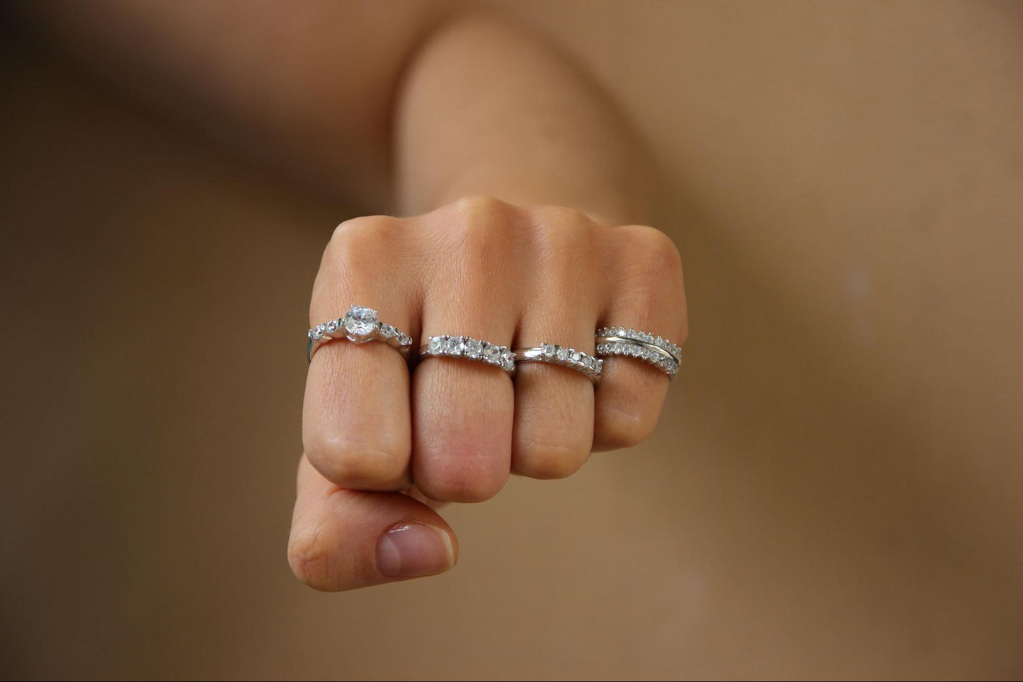 Photo of a hand with a diamond ring on each finger