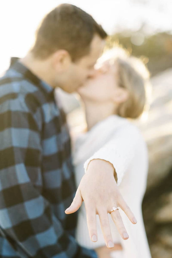 Photo of couple showing ring on hand to camera