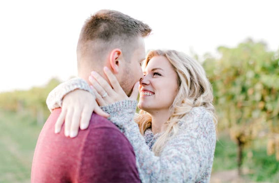 Photo of couple embracing and showing off engagement ring