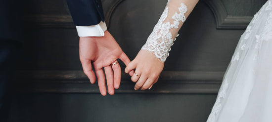 Close up photo of bride and groom holding hands